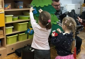 Dzieci dekorują choinkę