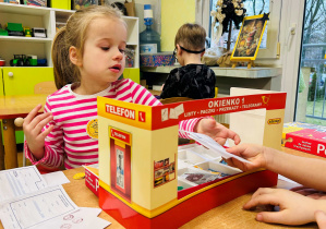 Dziewczynka podaje przekaz pocztowy