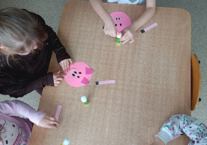 Dzieci pracują przy stolikach podczas pracy plastycznej