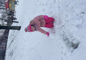 Dziewczynka bawi się na śniegu