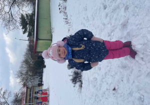 Dziewczynka bawi się na śniegu