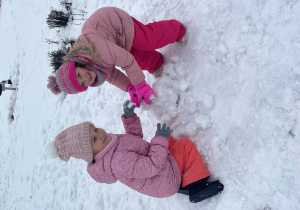 Dziewczynki bawią się na śniegu