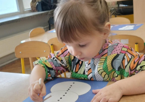 Dziewczynka wykonuje prace plastyczną