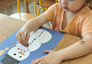 Dziewczynka wykonuje prace plastyczną