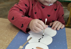 Dziewczynka wykonuje prace plastyczną