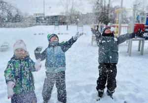 Dzieci podrzucają śnieg