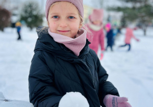 Dziewczynka zbudowała kulkę ze śniegu