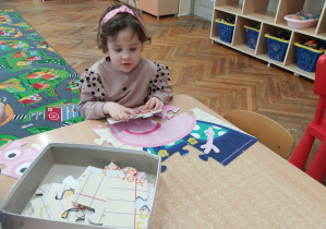 Dziewczynka układa puzzle
