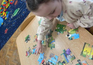 Dziewczynka układa puzzle