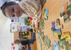 Dziewczynka układa puzzle