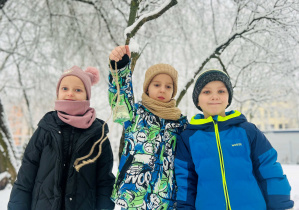 Dzieci idą karmić ptaki w ogrodzie przedszkolnym