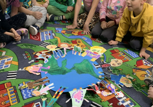 Dzieci podczas zajęć o czystym powietrzu siedzą na dywanie