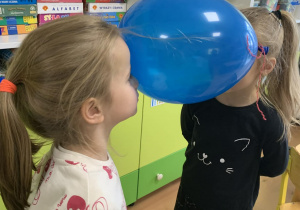 Dzieci trzymają balon głowami