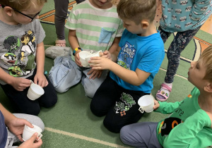 Dzieci przelewają wodę z kubków