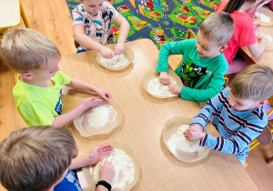 Chłopcy rysują w kaszy mannie
