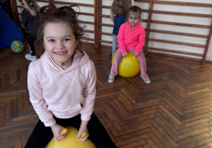 Dziewczynka skacze na piłce w sali korekcyjnej