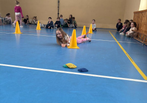 Dziewczynka przechodzi między pachołkami