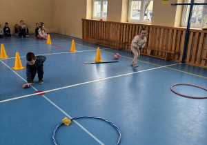 Dzieci biorą udział w konkurencji sportowej z rzucania do celu