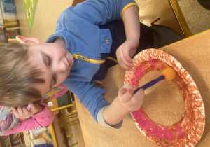 Chłopiec maluje swojego pączka