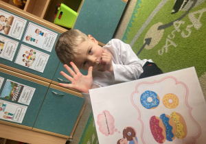 Chłopiec pokazuje cyfrę na palcach