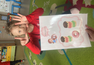 Dziewczynka pokazuje cyfrę na palcach