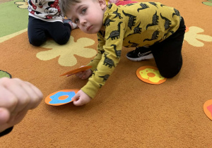 Chłopiec na dywanie układa pary obrazków