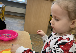 Dziewczynka wykonuje pracę plastyczną - pączka