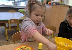 Dziewczynka wykonuje pracę plastyczną - pączka