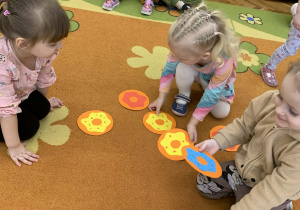 Dziewczynki na dywanie szukają par obrazków