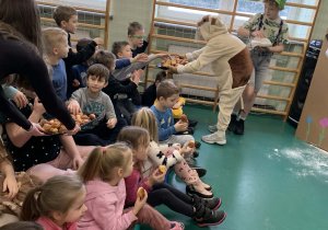 Uczniowie częstują przedszkolaki pączkami