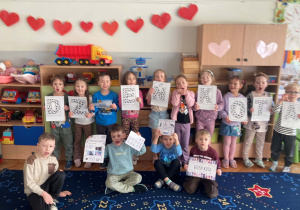 Dzieci pozują do wspólnego zdjęcia z okazji Dnia Kota