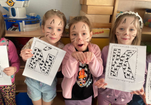 Dzieci pozują do wspólnego zdjęcia z okazji Dnia Kota