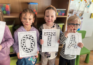 Dzieci pozują do wspólnego zdjęcia z okazji Dnia Kota