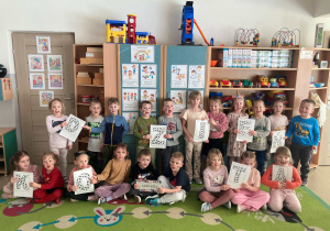 Dzieci pozują do wspólnego zdjęcia z okazji Dnia Kota