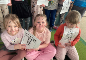 Dzieci pozują do wspólnego zdjęcia z okazji Dnia Kota