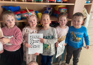 Dzieci pozują do wspólnego zdjęcia z okazji Dnia Kota