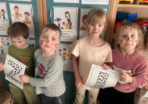 Dzieci pozują do wspólnego zdjęcia z okazji Dnia Kota