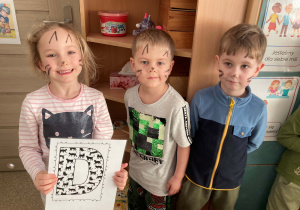 Dzieci pozują do wspólnego zdjęcia z okazji Dnia Kota