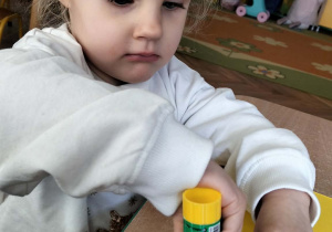 Dziewczynka wykonuje pracę plastyczną