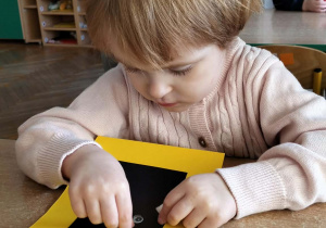 Dziewczynka wykonuje pracę plastyczną