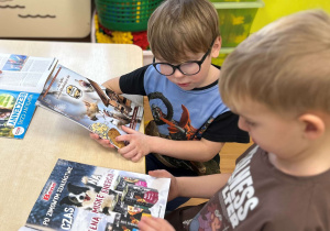 Dzieci oglądają gazety o zwierzętach