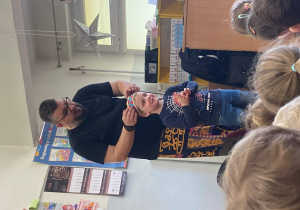 Pan prowadzący zakłada chłopcu czapkę