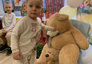 Chłopiec pozuje do zdjęcia z misiem