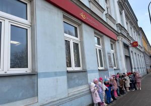 Dzieci stoją przed urzędem pocztowym