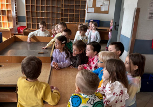 Dzieci słuchają opowieści na temat pracy listonosza i funkcjonowania urzędu