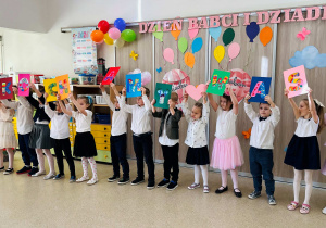 Dzieci prezentują napis dla Babci i Dziadka