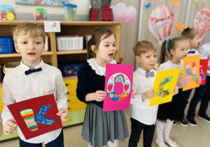 Dzieci prezentują napis dla Babci i Dziadka