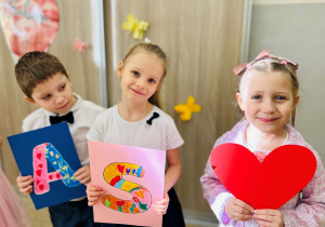 Dzieci prezentują napis dla Babci i Dziadka