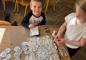 Chłopiec i dziewczynka przygotowują pracę plastyczną