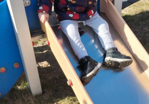 Chłopiec zjeżdża na zjeżdżalni